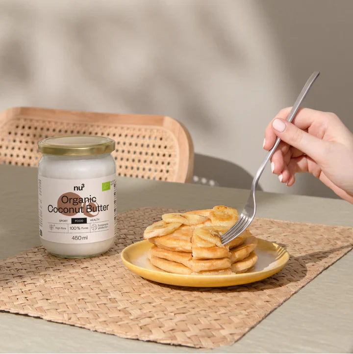 Gabel sticht in Pancakes, daneben nu3 Kokosbutter