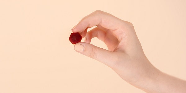 Hand mit einem Redcare Melatonin Weichgummi
