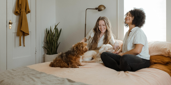 Zwei Frauen auf Bett mit Hund