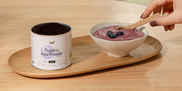 Hand hält Holzlössel Schüssel - Acai Pulver Bowl