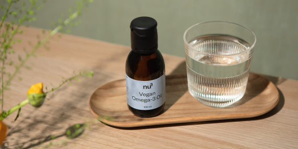 nu3 vegan Omega-3-Öl mit einem Glas Wasser