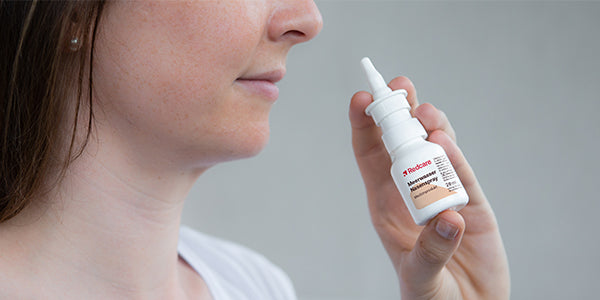 Person sprüht Spray in die Nase