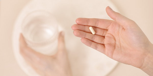 Hand mit einer Kapsel Redcare Vitamin C Depot