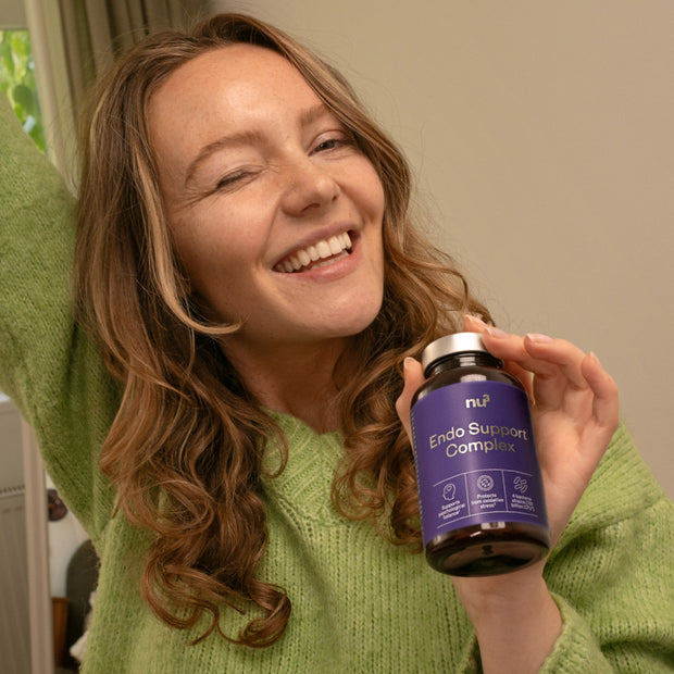 Lachende Frau mit Endo Komplex in der Hand