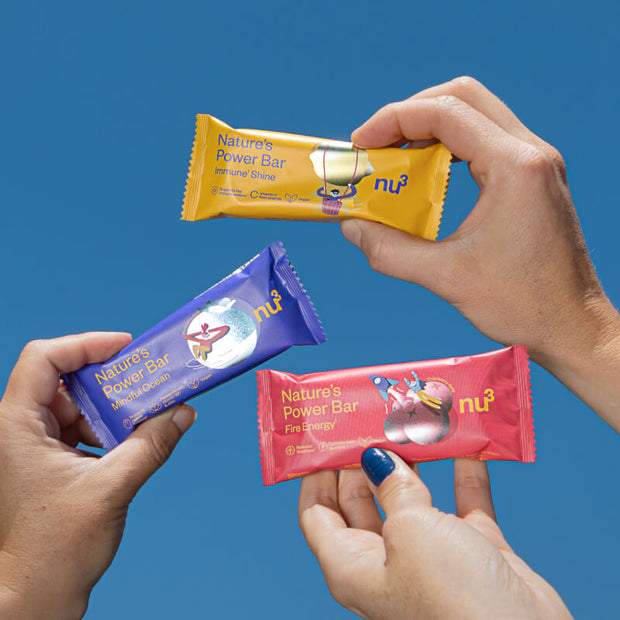 3 bunte Bars in der Hand vor blauen Himmel