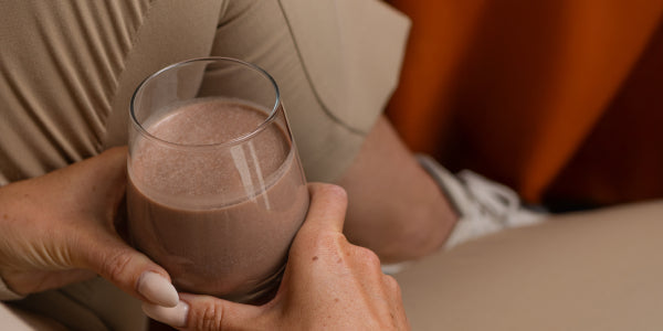 Hände halten Glas mit Schokodrink