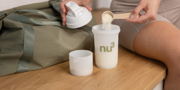 Shaker mit Proteinpulver und Messlöffel